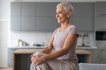 Cheerful Mature Woman Doing High Knees Exercise In Living Room