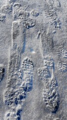 Footprints on a frozen lake in the mountains during a January hike.