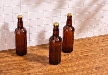 Three brown glass bottles of beer on a table. Alcohol, drinks and recreation.