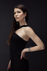 A woman looks elegant and stylish as she poses for a picture in her black dress.