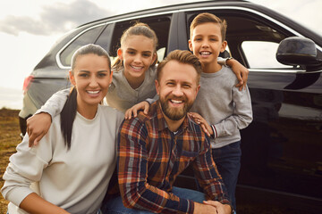 Close up family with children portrait on vehicle background. Smiles abound, revealing the genuine pleasure from autumn car travel at nature and the joyous moments of a vacation or holiday escape. - obrazy, fototapety, plakaty