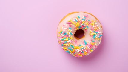  a frosted donut with sprinkles on a pink background with a bite taken out of it.