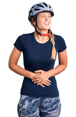 Beautiful caucasian woman wearing bike helmet with hand on stomach because nausea, painful disease feeling unwell. ache concept.