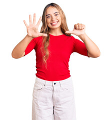Young beautiful blonde woman wearing casual clothes showing and pointing up with fingers number six while smiling confident and happy.