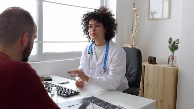 Female doctor and male patient talking in a medical consultation in a clinic. High quality 4k footage