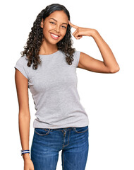 Young african american girl wearing casual clothes smiling pointing to head with one finger, great idea or thought, good memory