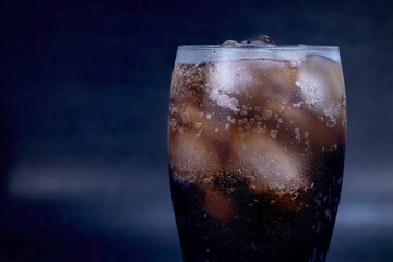Cool glass of cola drink with ice, bubbles and fizz