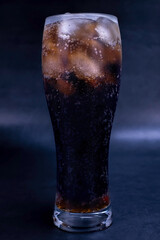 Cool glass of cola drink with ice, bubbles and fizz