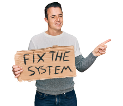 Handsome young man holding fix the system banner cardboard smiling happy pointing with hand and finger to the side