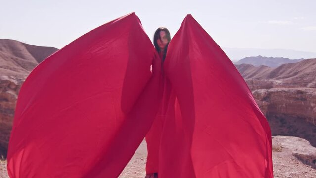 The girl in red over the canyon cliff. Slow motion.