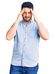 Fototapeta premium Young hispanic man wearing casual clothes suffering from headache desperate and stressed because pain and migraine. hands on head.