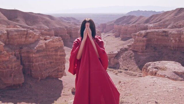 The girl in red over the canyon cliff. Slow motion.