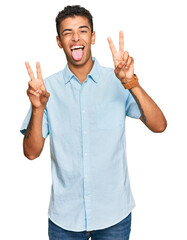 Young handsome african american man wearing casual clothes smiling with tongue out showing fingers...