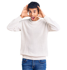 Naklejka premium Young african amercian man wearing casual clothes smiling cheerful playing peek a boo with hands showing face. surprised and exited