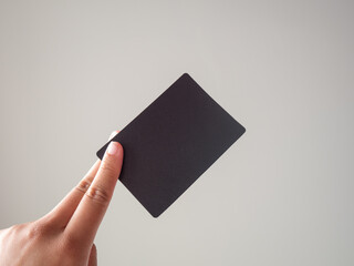 Présentation d'une carte noir vierge tenue entre deux doigts