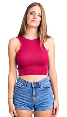 Fototapeta premium Young beautiful blonde woman wearing elegant summer shirt relaxed with serious expression on face. simple and natural looking at the camera.