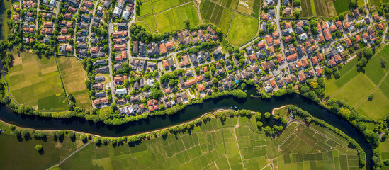 Obraz premium Banner of aerial satellite view of cultivated agricultural farming land fields with vivid green color as a typical European or countryside farmland village town with canal river