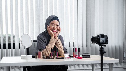 Happy asian muslim woman beauty blogger recording vlog video about new product cosmetic