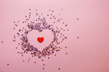 Pink pastel background with small hearts confetti. Flatlay, top view, copy space