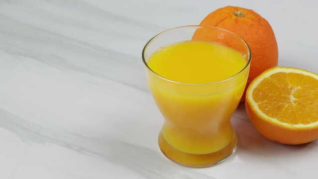 verre de jus d'orange et oranges fraiches sur une table