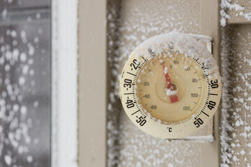 Snow Capped Thermometer Mounted on Wooden Siding of House Showing Freezing Temperatures