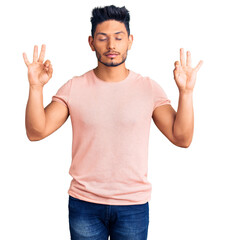 Handsome latin american young man wearing casual clothes relax and smiling with eyes closed doing meditation gesture with fingers. yoga concept.