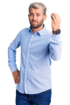 Young handsome blond man wearing elegant shirt doing italian gesture with hand and fingers confident expression