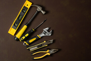 Set of hand tools on a brown background.