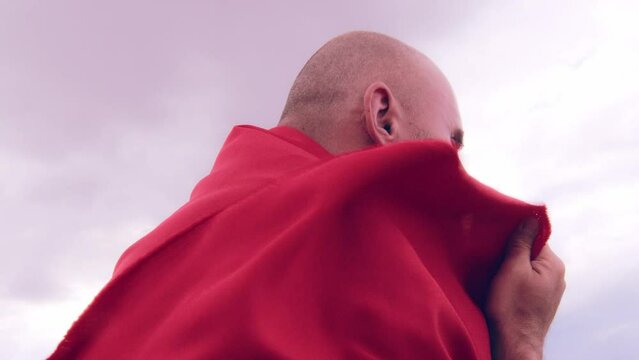 A monk in red prays in the steppe. A divine ritual.