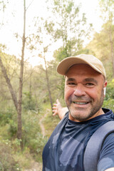Naklejka na ściany i meble Happy hiker takes a phot selfie showing the landscape.
