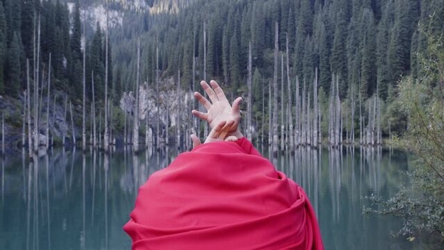 A monk in red prays in the steppe. A divine ritual.