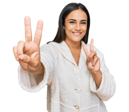 Young brunette woman wearing casual clothes smiling looking to the camera showing fingers doing victory sign. number two.