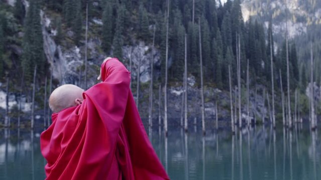 A monk in red prays in the steppe. A divine ritual.