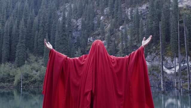 A monk in red prays in the steppe. A divine ritual.