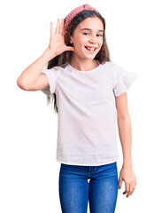 Obraz premium Cute hispanic child girl wearing casual white tshirt smiling with hand over ear listening an hearing to rumor or gossip. deafness concept.