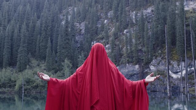 A monk in red prays in the steppe. A divine ritual.
