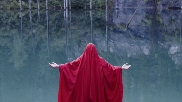 A monk in red prays in the steppe. A divine ritual.