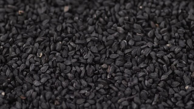 close-up of a bunch of black cumin seeds rotation. Asian spices for cooking. beneficial properties of black cumin