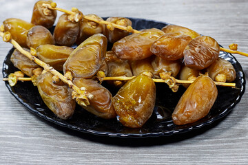 black plate of Algeria branch fresh dates on wood table. Package design elements with clipping path