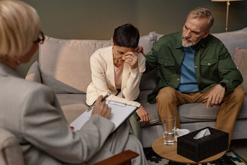 Portrait of mature adult couple trying to resolve conflict in couples therapy session