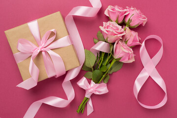 Composition with pink roses, gift box and eight made of ribbon on color background, top view. Women's day concept