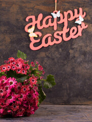 A bouquet of pink spring flowers on a metallic background with an Easter inscription