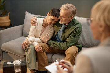 Portrait of mature adult couple embracing and supporting each other in couples therapy session