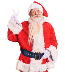 Old senior man with grey hair and long beard wearing traditional santa claus costume smiling looking to the camera showing fingers doing victory sign. number two.