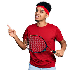 Young african american man wearing tennis player uniform smiling happy pointing with hand and...