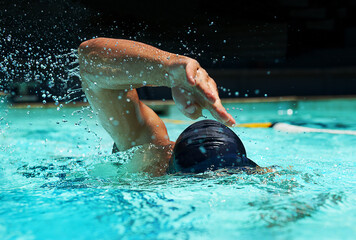 Pool, water splash and athlete swimming in sport for competition, race or training in cardio. Fitness, workout and person exercise for health, wellness or practice stroke or performance in gym