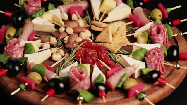 Appetizers boards with assorted cheese, salami, ham, olives and nuts. Charcuterie and cheese platter close-up. Top view. Video is looped