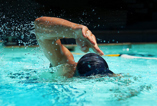 Pool, water splash and athlete swimming in sport for competition, race or training in cardio. Fitness, workout and person exercise for health, wellness or practice stroke or performance in gym