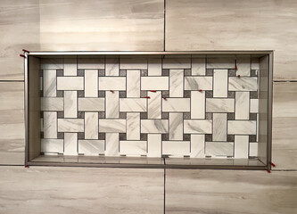 Close up of shower wall with built in niche. Unique pattern with stone tile wall