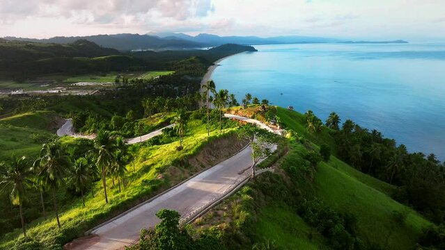 Aerial view of a scenic road along the coastline with high cliffs and beautiful beach in San Vicente Viewpoint, Palawan, Philippines.